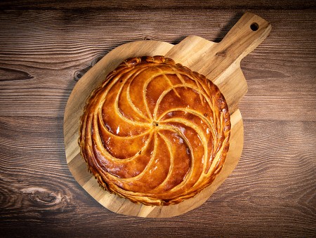 round golden cake shown from above on a wooden flat dish like fresh out of the oven