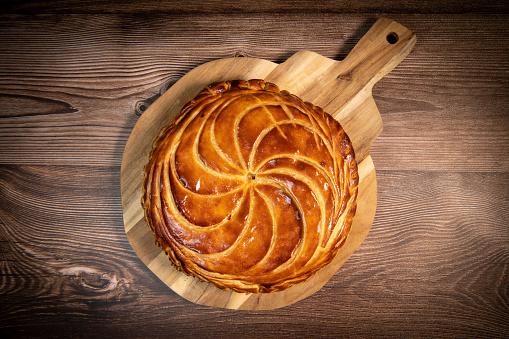 round golden cake shown from above on a wooden flat dish like fresh out of the oven