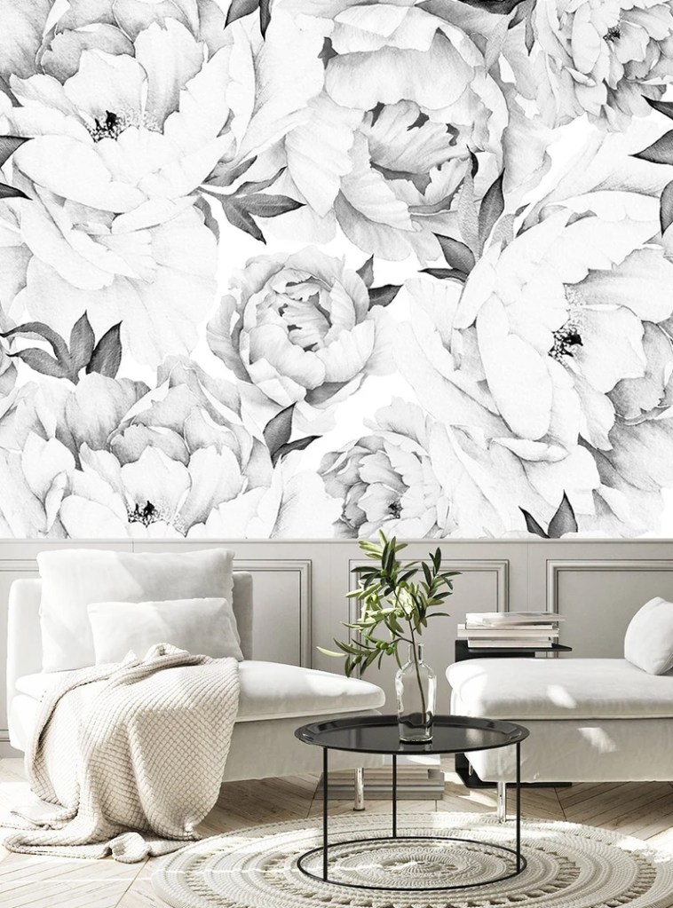 Black and White peonies flowers on a wall behind 2 armchairs