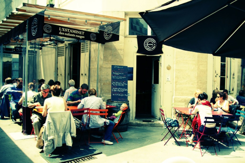 Tables in front of the L’Estaminet restaurant with people eating.
